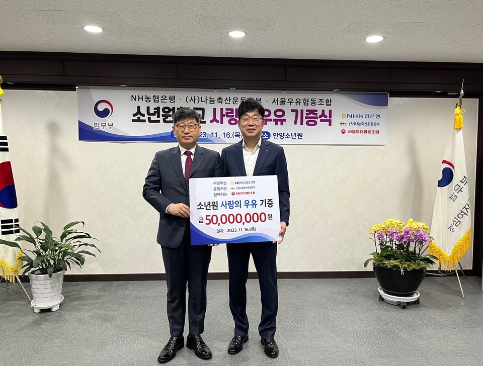 윤웅장 법무부 윤웅장 범죄예방정책국장(왼쪽)과 금동명 NH농협은행 공공금융부문 부행장이 16일 정심여자중고등학교(안양소년원)에서 열린 사랑의 우유 나눔행사에 참석해 기념촬영을 하고 있다.사진=NH농협은행