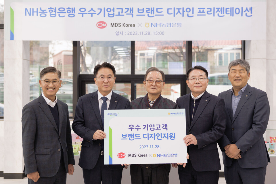 28일 경기 파주시 소재 MDS코리아에서 열린 브랜드 디자인 지원 현판식 행사에서 이석용 농협은행장(왼쪽 두번째), 문동준 MDS코리아 대표이사(가운데) 및 임직원들이 기념촬영을 하고 있다. 사진=NH농협은행