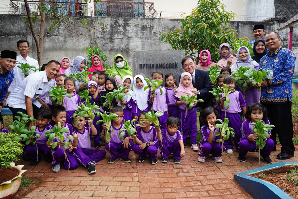 행사에 참석한 홍정표 한화생명 부사장(2열 오른쪽 세번째)과 현지 주민, 아이들이 커뮤니티 활동에 참여한 후 기념촬영을 하며 웃고 있다. 사진=한화생명