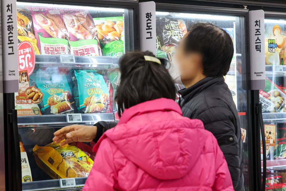 정부가 용량 축소 등을 통한 편법 가격인상을 의미하는 '슈링크플레이션' 실태조사를 진행하겠다고 발표한 가운데 19일 서울 시내 한 대형마트에서 시민들이 과자를 고르고 있다. 사진=연합뉴스