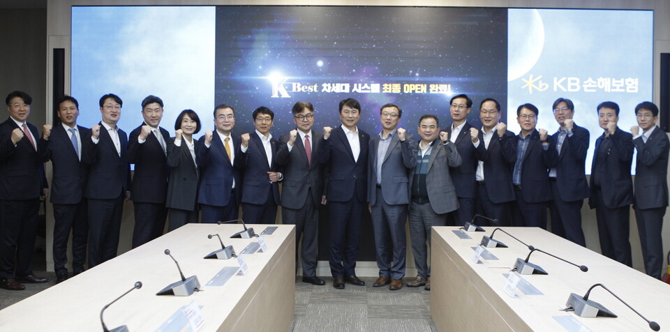 KB손해보험 구본욱 사장(왼쪽부터 아홉번째)과 프로젝트 참여 관계자 및 임직원들이 새로워진 ‘K-BEST 차세대시스템’을 시연하며 함께 기념촬영을 하고 있다. 사진=KB손해보험
