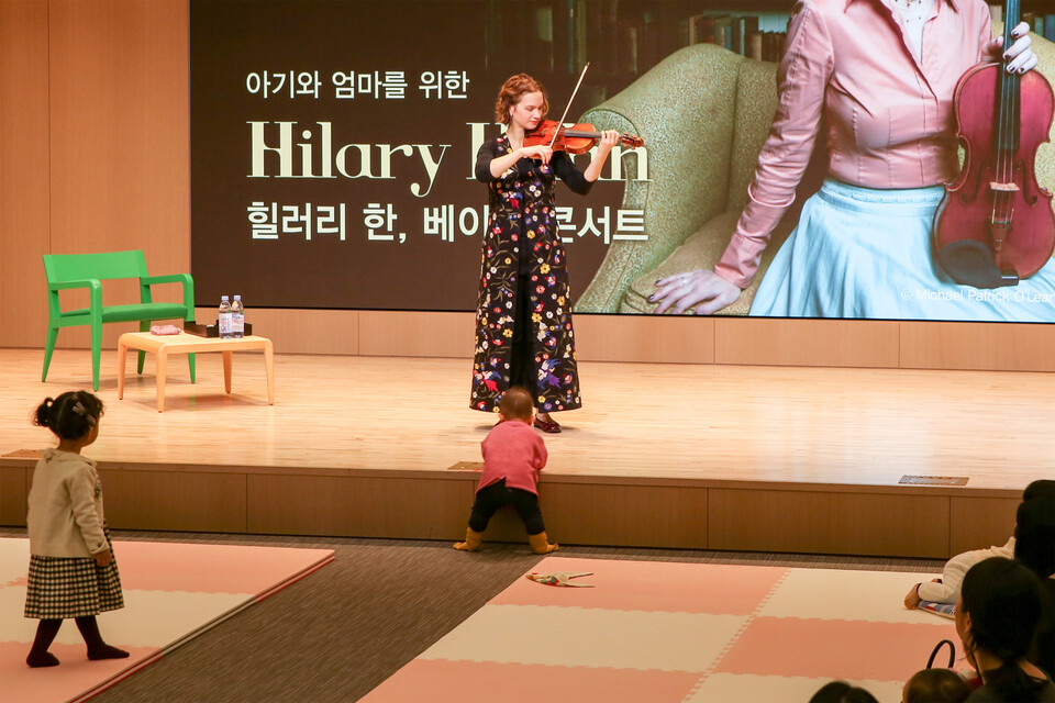 신영증권 본사에 위치한 70여석 규모의 클래식 전문 공연장 신영체임버홀은 개관 이후 당 타이 손·백혜선·선우예권·힐러리 한(이상 가나다순) 등 세계적인 음악가를 초청해 다양한 기획 공연을 선보이고 있다. 피아노 및 소규모 실내악 연주에 최적화됐으며, 음향학 전문가의 청취 시험과 컴퓨터 시뮬레이션을 거친 최상의 음향 환경을 자랑한다. 지난 2018년 12월 서울 영등포구 신영체임버홀에서 열린 ‘아이과 엄마를 위한 베이비 콘서트’에서 바이올리니스트 힐러리 한이 어린 관객들 앞에서 곡을 연주하고 있다. 사진=신영증권