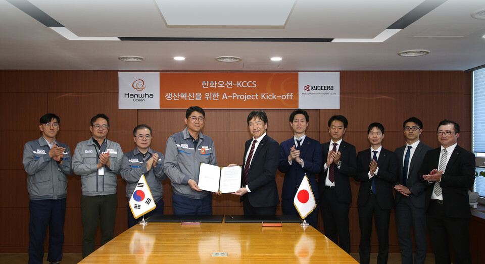 이길섭 한화오션 조선소장 부사장(왼쪽에서 네번째)이 마츠나가 카즈히로 교세라 사업부장(왼쪽에서 다섯번째)과 계약서에 서명하고 기념 촬영하는 모습. 사진=한화오션