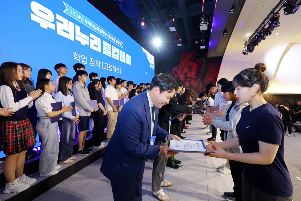 우리다문화장학재단은 서울 중구 소재 우리은행 본점에서 다문화학생 장학금 전달식인 ‘2024년 우리누리 웰컴데이’를 개최했다. 이날 참석한 선배 장학생들이 후배 장학생에게 장학증서를 수여하고 있다. 사진=우리은행