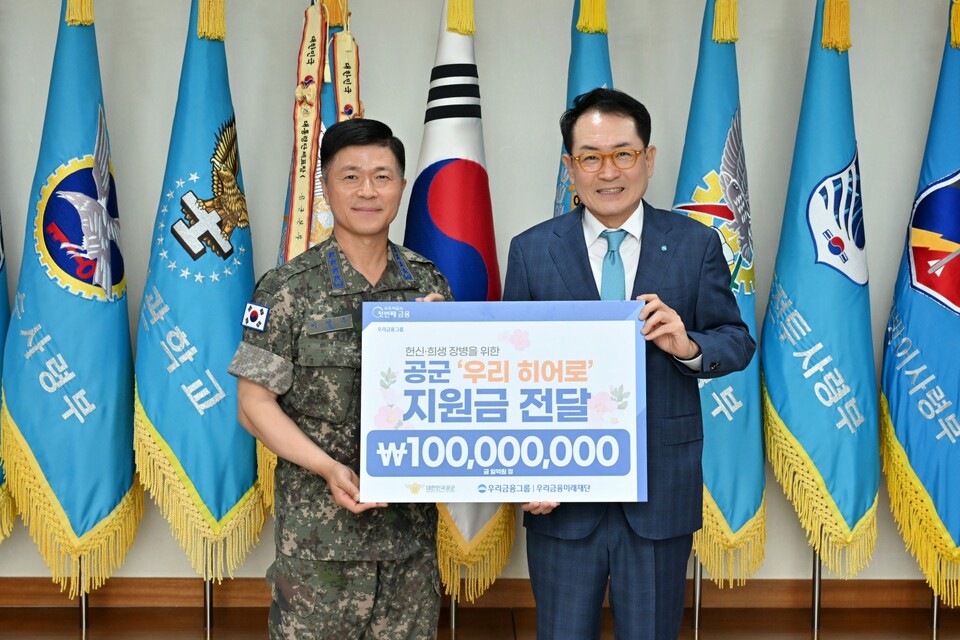 우리금융그룹 우리금융미래재단은 10일 충남 계룡대에서 육·해·공군 참모총장과 함께 국가와 국민을 위해 헌신한 ‘우리 히어로’ 지원금 전달식을 가졌다. 이영수 공군참모총장(왼쪽)과 장광익 우리금융지주 부사장이 공군 '우리 히어로’를 위한 지원금 전달식에서 기념촬영을 하고 있다. 사진=우리금융그룹