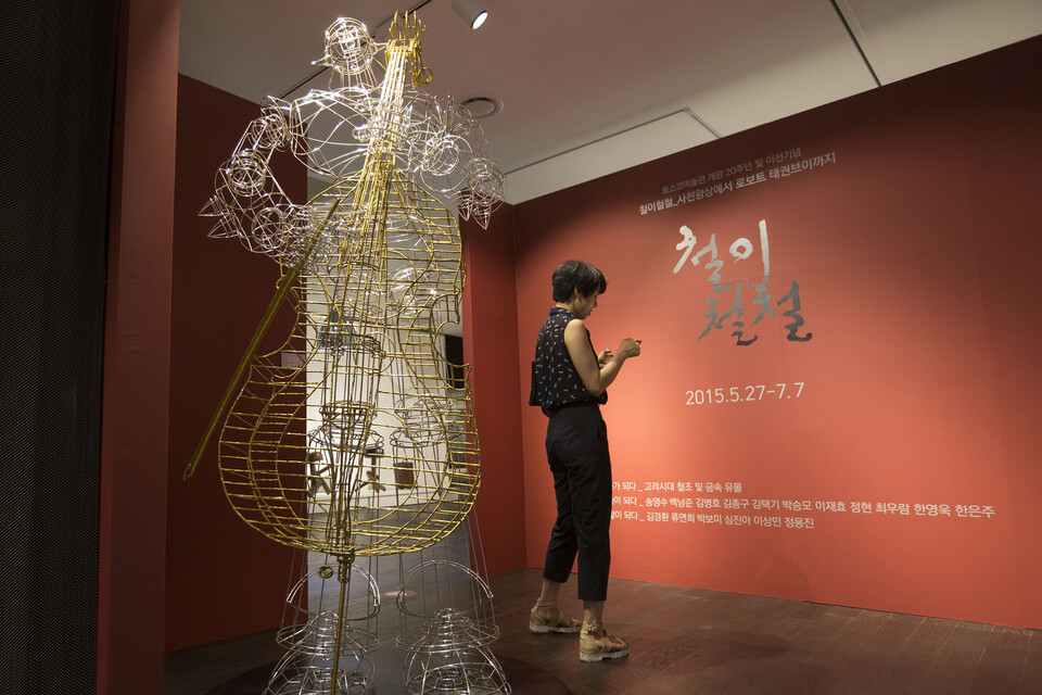 지난 2015년 5월 서울 강남구 포스코센터 포스코미술관에서 열린 개관 20주년 기념전 ‘철이철철-사천왕상에서 로보트 태권브이까지’를 찾은 시민이 전시품을 구경하고 있다. 고대 유물 20점과 함께, 한국 조각 1세대인 송영수·정현 작가의 철 조각상, 류연희 작가의 금속 공예, 김경환 작가의 철제 가구 디자인 등 총 80점의 작품이 공개됐다. ‘철이철철’이라는 전시회 제목은 포스코센터 1층 로비에 설치된 백남준 작가의 ‘철이 철철-TV 깔때기, TV 나무’에서 따온 것으로, 백 작가는 작품 설치 당시 “철 만드는 회사니 철이 철철 넘쳐 나라”며 포스코의 발전을 기원했다. 사진=연합뉴스