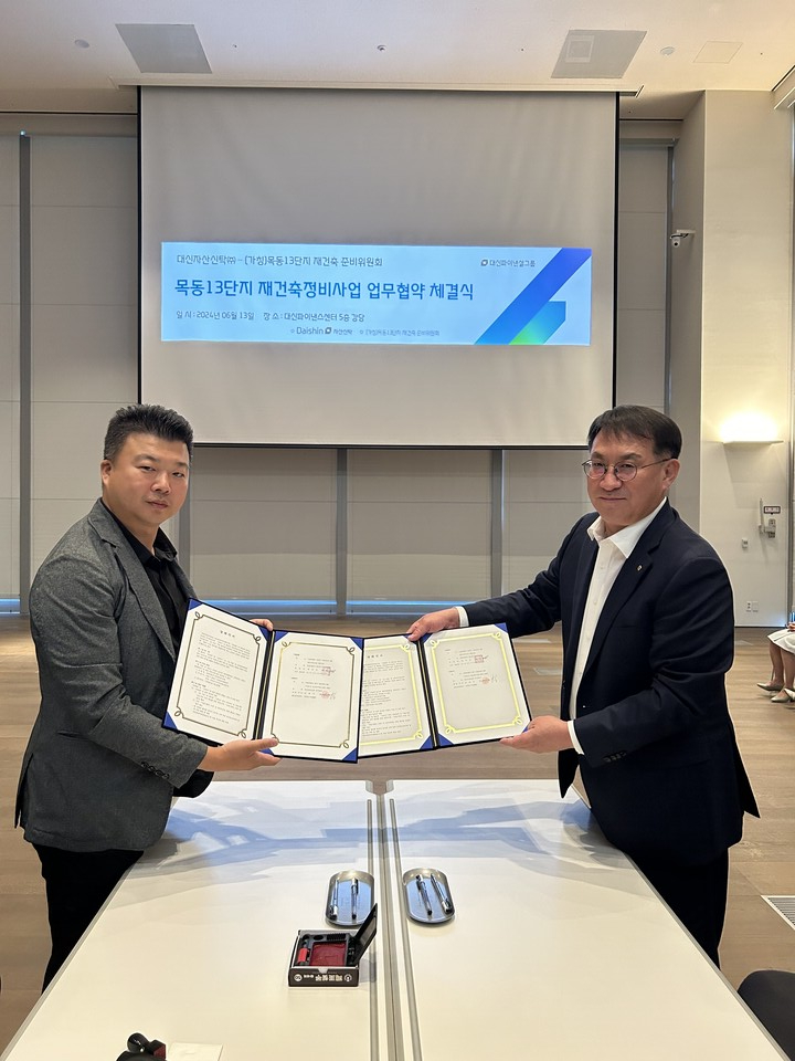 양국진 목동13단지 재건축준비위원장(왼쪽)과 김송규 대신자산신탁 대표이사가 정비사업을 위한 업무협약을 맺고 사진을 촬영하고 있다. 사진=대신증권