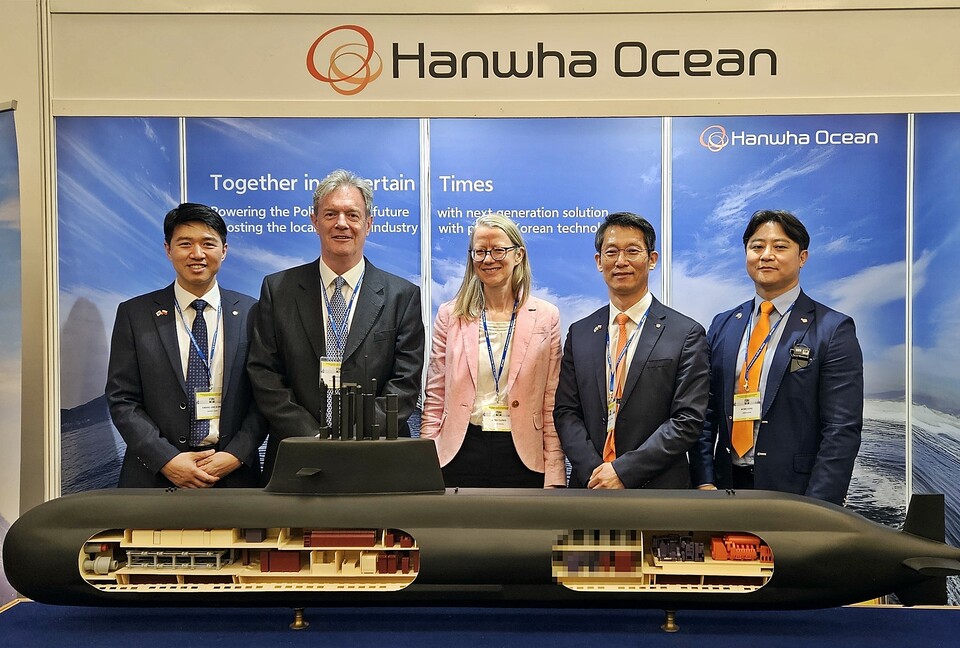 영국 밥콕 인터내셔널 국제 부문 총괄 닉 하인 경(왼쪽에서 두번째) , 폴란드 주재 영국 대사 안나 클룬즈(왼쪽에서 세번째)와 한화오션 정승균 특수선 해외사업단장(오른쪽에서 두번째) 등 관계자들이 지난 20일 폴란드 바르샤바에서 열린 국제 해양 안보 포럼에 참가, 한화오션이 별도 마련한 전시 부스를 방문해 기념촬영을 하는 모습. 사진=한화오션