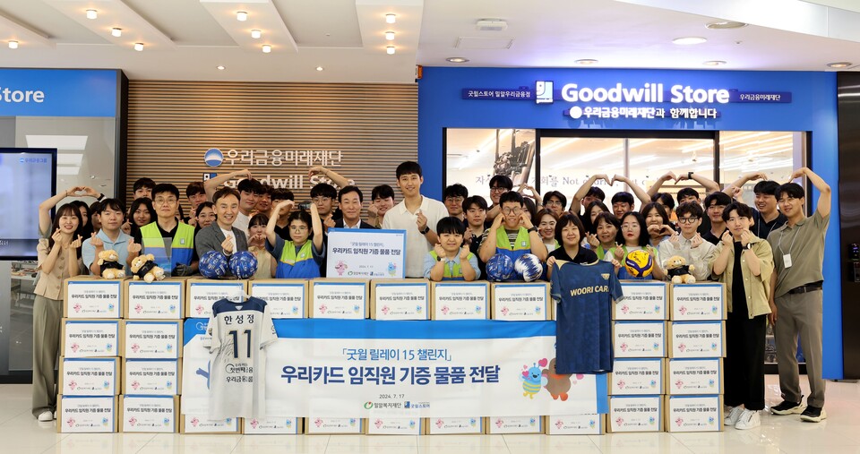 박완식 우리카드 대표이사(가운데 팻말 뒤)를 비롯한 임직원 30명과 한성정 우리카드 배구단 선수(대표이사 오른쪽)가 굿윌스토어에서 기증식 후 기념촬영을 하고 있다. 사진=우리카드