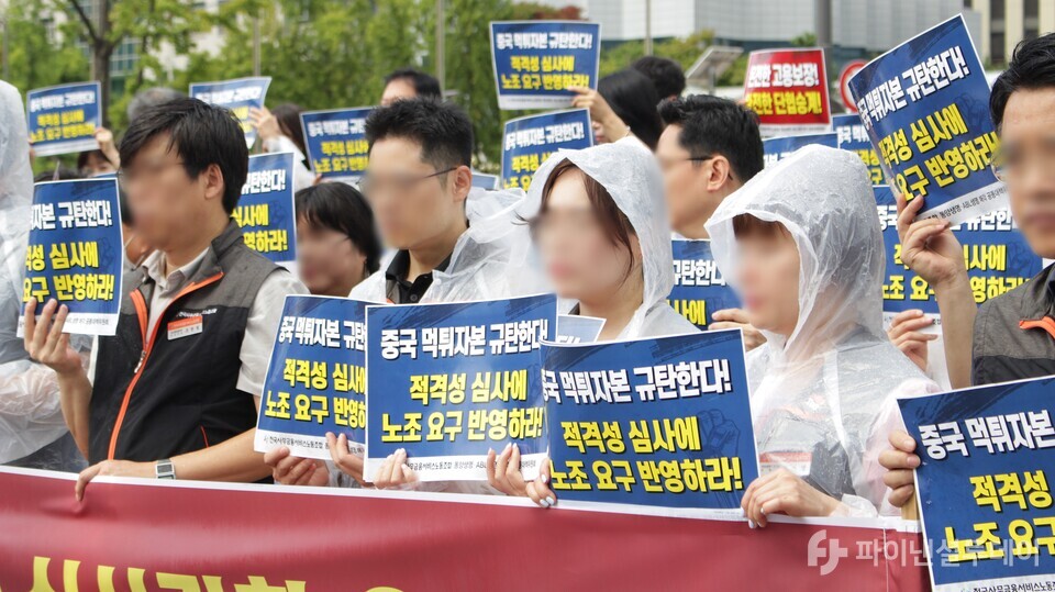 24일 오전 금융위원회 앞에서 진행된 기자회견에 참석한 노조 관계자들이 피켓을 들고 있다. 사진=신수정 기자