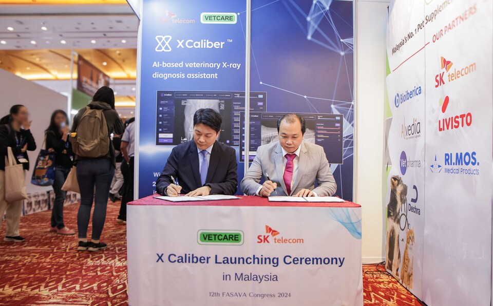 지난 19일 말레이시아 쿠알라룸푸르 글로벌 반려동물 포럼 ‘FASAVA Congress 2024’에서 장동일 SKT 엑스칼리버 글로벌팀장(사진 왼쪽)과 리우 창 할(Dr. Liu Chang Hair) 마이벳케어 사업총괄이 계약을 체결하고 있는 모습. 사진=SK텔레콤
