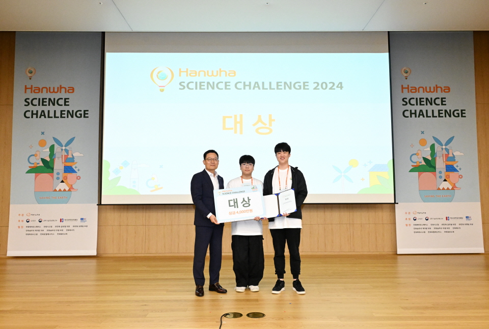 한화사이언스챌린지 2024에서 시상자 대표인 한화에어로스페이스 손재일 대표가 대상 수상자인 함성준(좌), 김정헌(우)에게 상패를 시상하고 있다. 사진=한화그룹