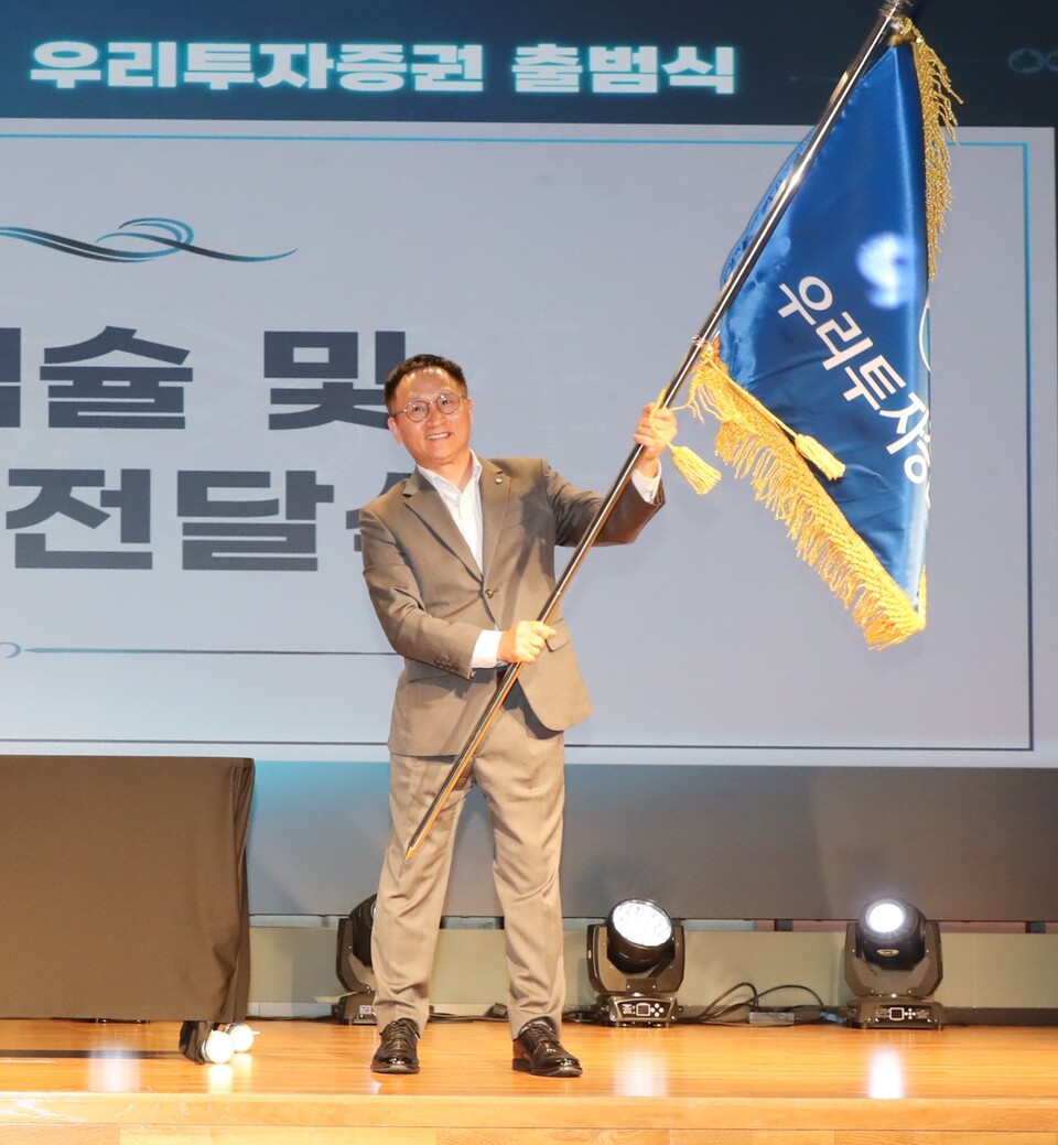 남기천 우리투자증권 대표이사가 출범기념식에서 깃발을 흔들고 있다. 사진=우리투자증권