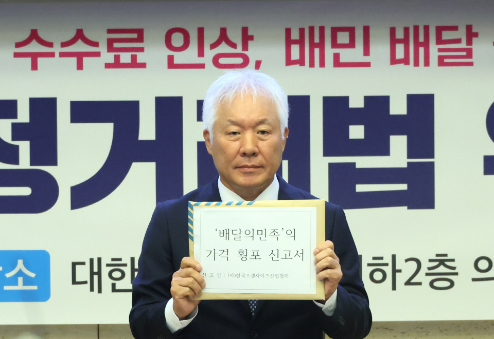 정현식 한국프랜차이즈산업협회 회장이 27일 오전 서울 중구 대한상의에서 한국프랜차이즈산업협회 주최로 열린 '배달의 민족' 공정거래법 위반 신고 기자간담회에서 가격 횡포 신고서를 들어 보이고 있다. 사진=연합뉴스