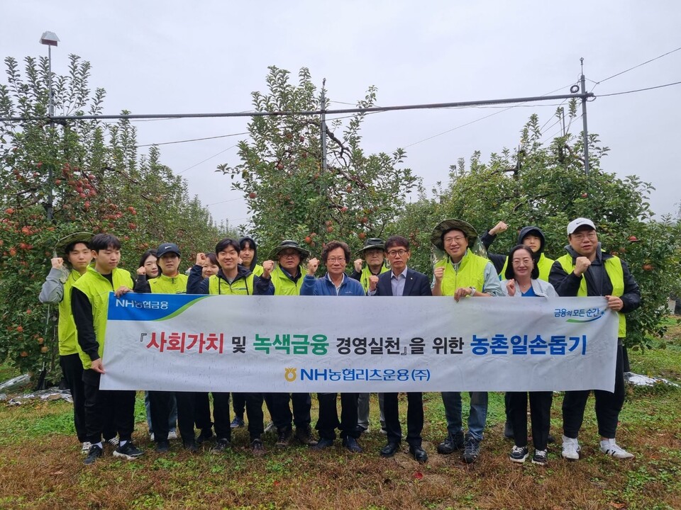정규경 NH농협리츠운용(앞줄 왼쪽 네 번째) 준법감시인과 임직원들이 지난 22일 포천시 소재 사과농가를 방문해 일손돕기를 마치고 농가에서 기념촬영을 하고 있다. 사진=NH농협리츠운용