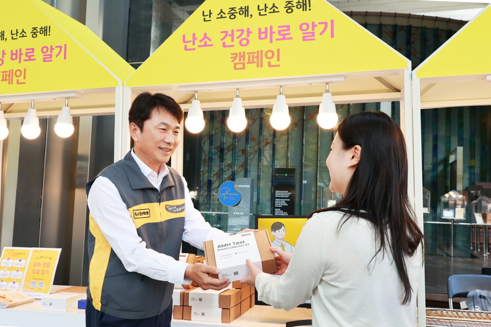KB손해보험 본사 로비에서 구본욱 사장(왼쪽)이 행사에 참여한 여성에게 난소 나이 자가검사 진단 키트를 전달하고 있다. 사진=KB손해보험