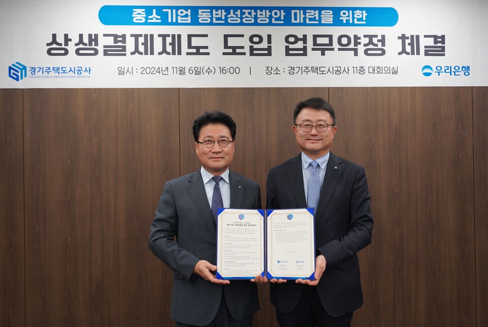 안상태 경기주택도시공사 경영기획본부장(왼쪽)이 조세형 우리은행 기관그룹 부행장과 6일 경기주택도시공사에서 열린 ‘상생결제제도 도입 업무약정’ 체결식에 참석해 기념 촬영을 하고 있다. 사진=우리은행