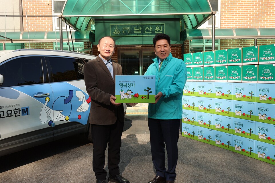 함영주 하나금융그룹 회장(오른쪽)이 청각장애인 운전사가 운전한 '고요한 M' 택시를 타고 중구 예장동에 위치한 아동보육시설 '남산원'에 방문해 임직원의 정성이 담긴 김장김치와 간식을 담은 행복상자를 전달했다. 사진=하나금융그룹