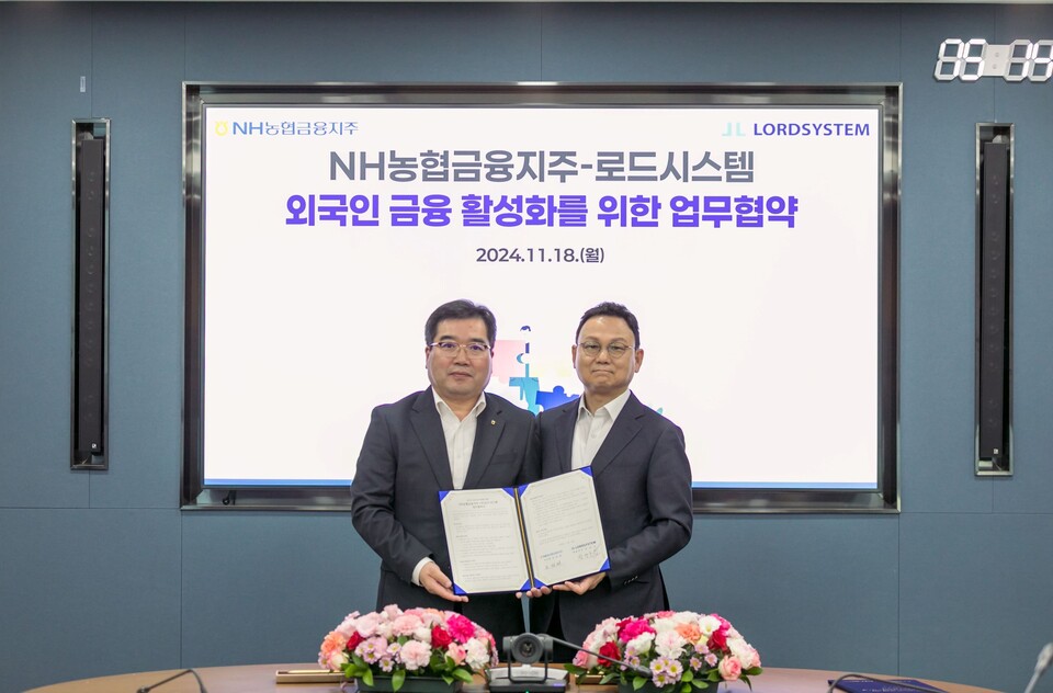 조정래 NH농협금융 미래성장부문 부사장(왼쪽)과 장양호 로드시스템 대표(오른쪽)가 업무협약 직후 기념촬영을 하고 있다. 사진=NH농협금융