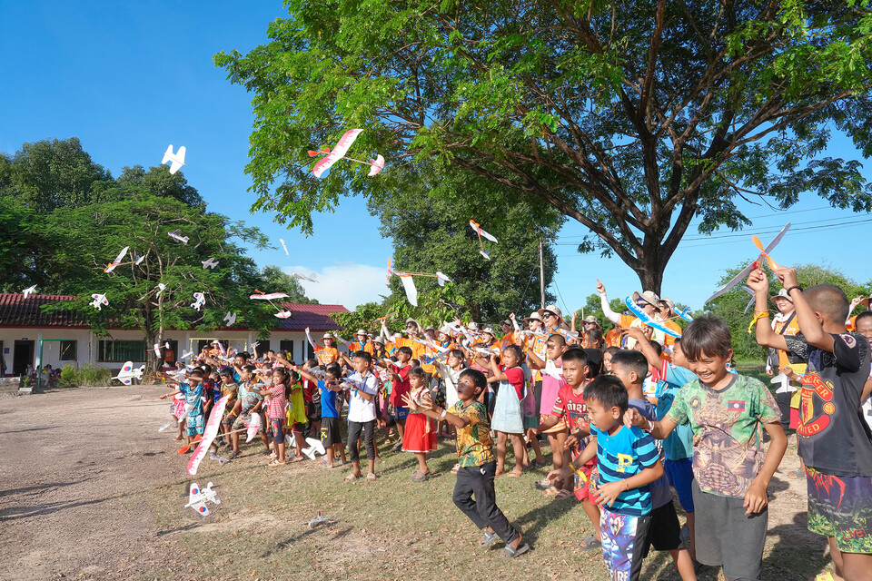 교보다솜이글로벌봉사 단원들과 라오스 나노마을 아이들이 초등학교에서 비행기를 날리고 있다. 사진=교보생명