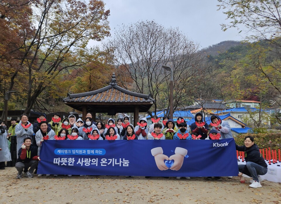 케이뱅크 임직원이 21일 서울시 서대문구 홍제동 개미마을에서 진행된 ‘금융권 사랑의 온기나눔’ 활동에 참여해 기념촬영을 하고 있다. 사진=케이뱅크