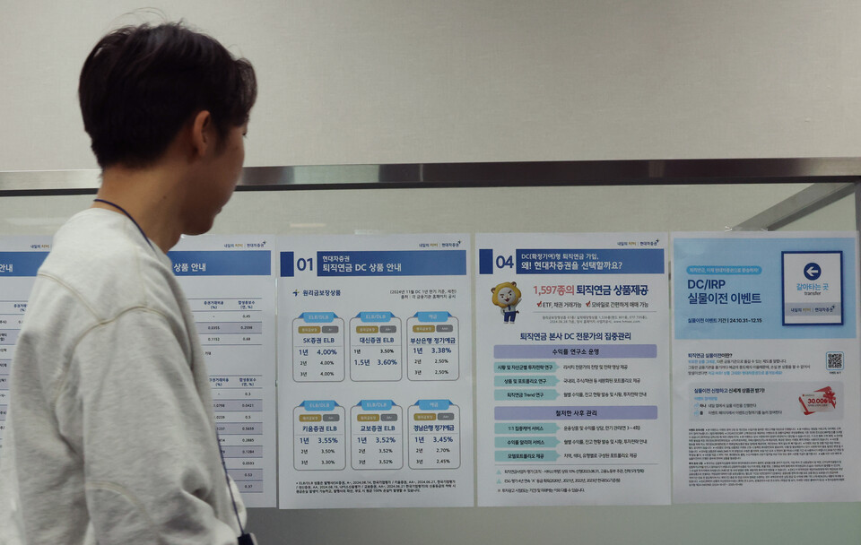 서울 한 증권사 영업점에서 관계자가 지난달 31일 퇴직연금 실물이전 서비스 관련 홍보물을 부착하고 있다. 사진=연합뉴스