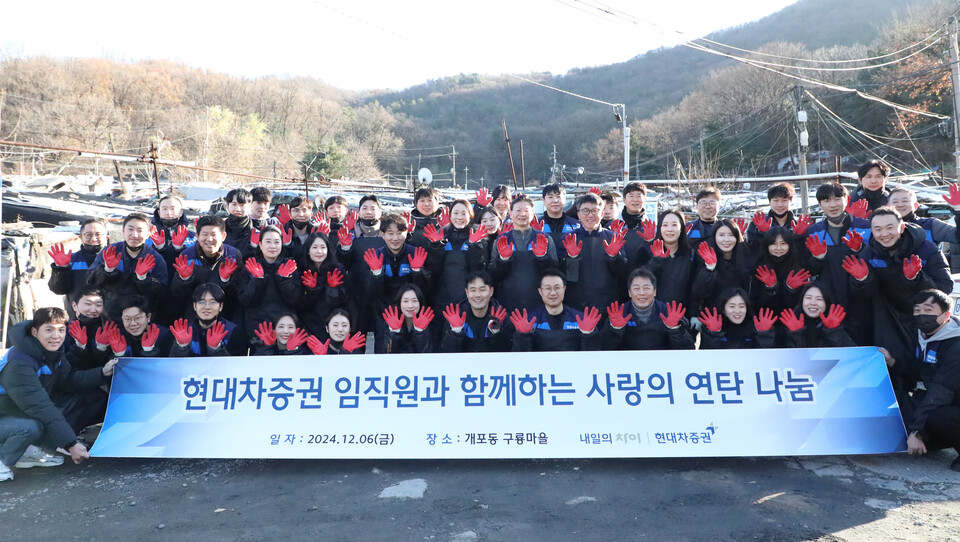 현대차증권 임직원이 6일 서울 강남구 개포동 구룡마을에 모여 연탄 나눔 봉사활동을 하고 단체 기념 사진을 촬영하고 있다. 사진=현대차증권