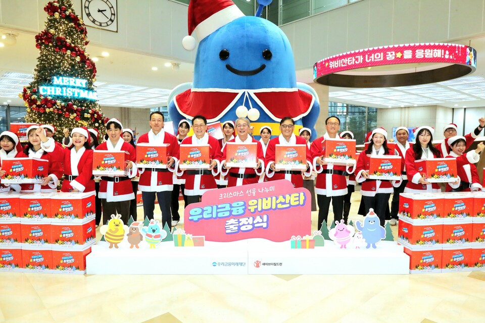 임종룡 우리금융그룹 회장(오른쪽 여섯번째), 정태영 세이브더칠드런 총장(오른쪽 다섯번째)과 우리금융그룹 임직원이 위비산타 출정식 구호를 외치고 있다. 사진=우리금융그룹