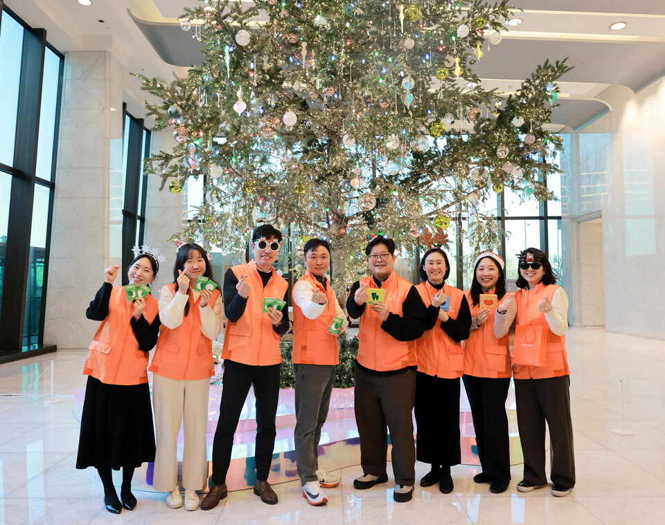 한화생명 봉사단원들이 올해를 마무리하며 앞서 23일 본사인 63빌딩 로비에 세워진 크리스마스 트리 앞에서, 내년도 적극적인 사회공헌 활동 참여를 다짐하는 기념촬영을 하고 있다. 사진=한화생명