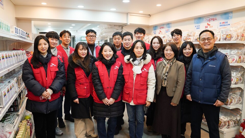 SK증권 직원들이 9일 서울시립 서울역쪽방상담소에 쪽팡촌 주민들을 위한 물품 키트를 배송하고 기념 사진을 촬영하고 있다. 사진=SK증권