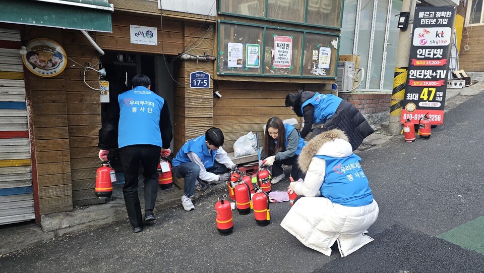우리금융그룹 임직원들이 지난 11일 서울 용산구 동자동 인근에 있는 쪽방촌 주민들을 위해 소화기를 점검하고 있다. 사진=우리금융그룹