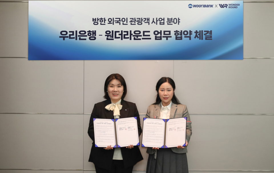 방윤선 우리은행 외환사업부장 (왼쪽)과 묘청(MIAO QING) 원더라운드 대표이사가 방한 외국인 관광객 사업 분야 협약 체결 후 기념촬영을 하고 있다. 사진=우리은행