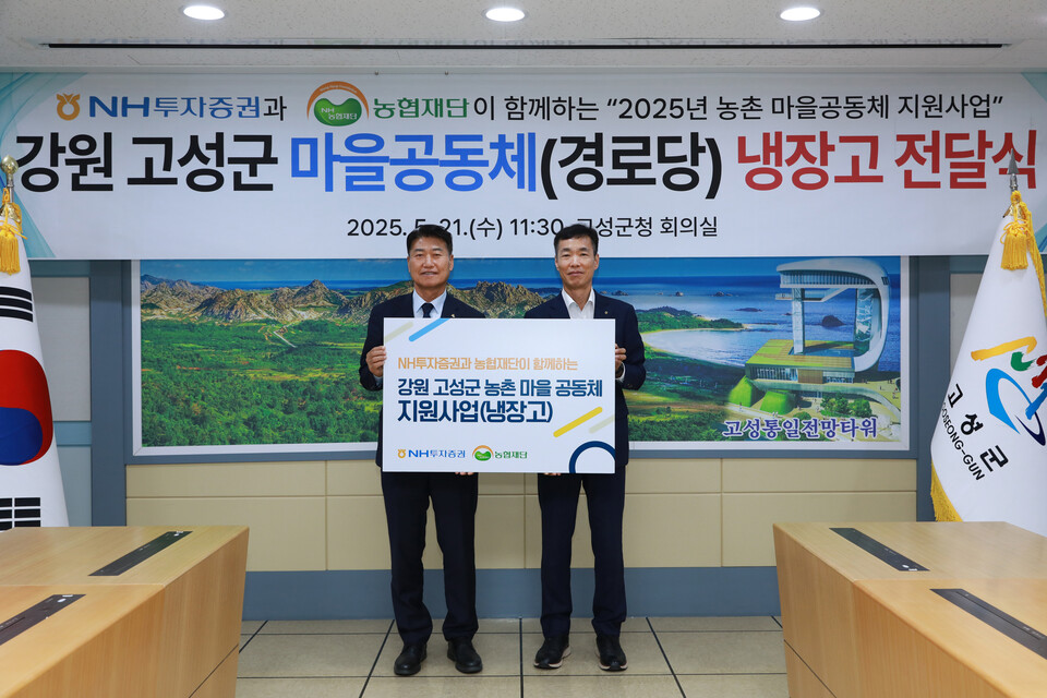 함명준 고성군수(왼쪽)과 김석찬 NH투자증권 부사장이 21일 강원 고성군에 냉장고 20대를 전달한 후 진행한 기념식에서 기념 사진을 촬영하고 있다.