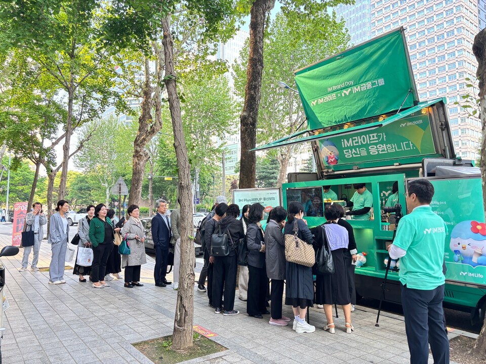 iM라이프가 진행한 브랜드데이 행사에서 법인보험대리점(GA) 관계자들이 민트색 커피차 이벤트에 참여하고 있다. 사진=iM라이프