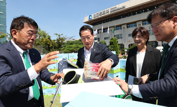 김진우 하나은행 중앙영업그룹 부행장(사진 왼쪽에서 첫번째)이 12일 인천광역시와 지역사회 시니어 일자리 창출과 취약계층 지원을 위한 업무협약식에서 유정복 인천시장(사진 가운데)과 함께 폐지 수거 어르신을 위한 행복상자 구성품을 살펴 보고 있다. 사진=하나금융그룹