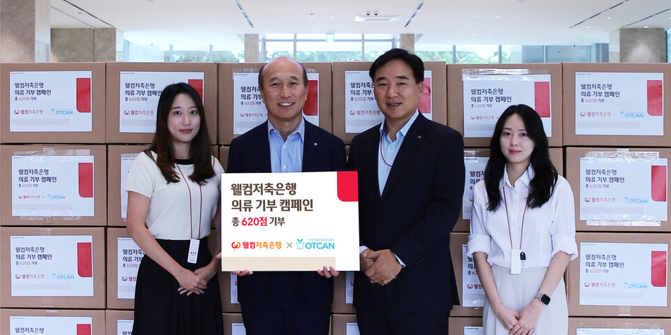 김대웅 웰컴저축은행 대표(왼쪽 두 번째)와 임직원들이 기부 의류상자 앞에서 기념 촬영을 하고 있다. 사진=웰컴저축은행