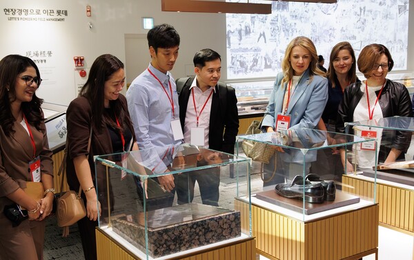 롯데 글로벌 컨퍼런스 참가자들이 롯데월드타워 위치한 신격호 롯데 창업주 기념관을 방문해 실물 자료를 살펴보고 있다. 사진=롯데그룹